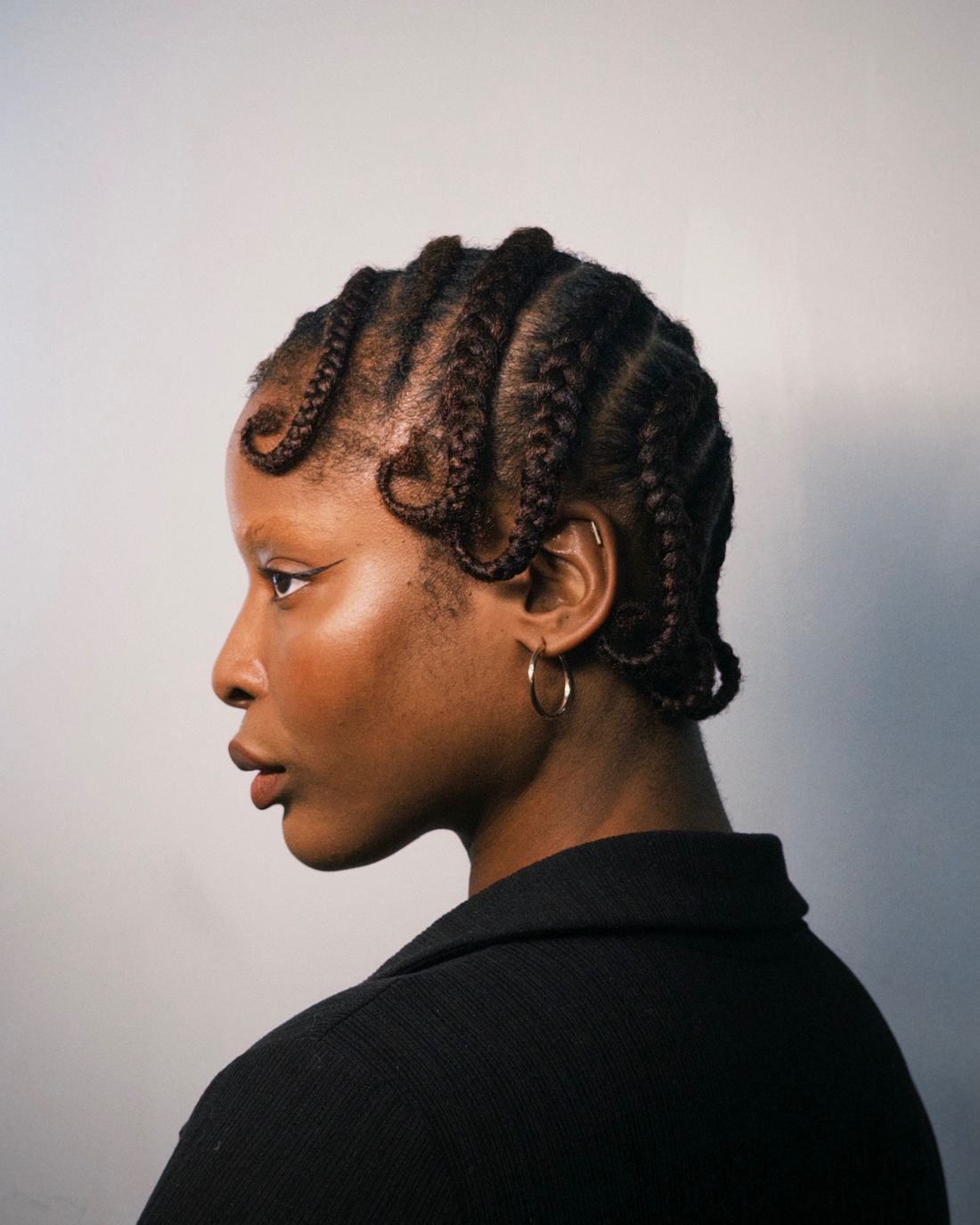 Sculpted cornrows with looped ends, seen in profile